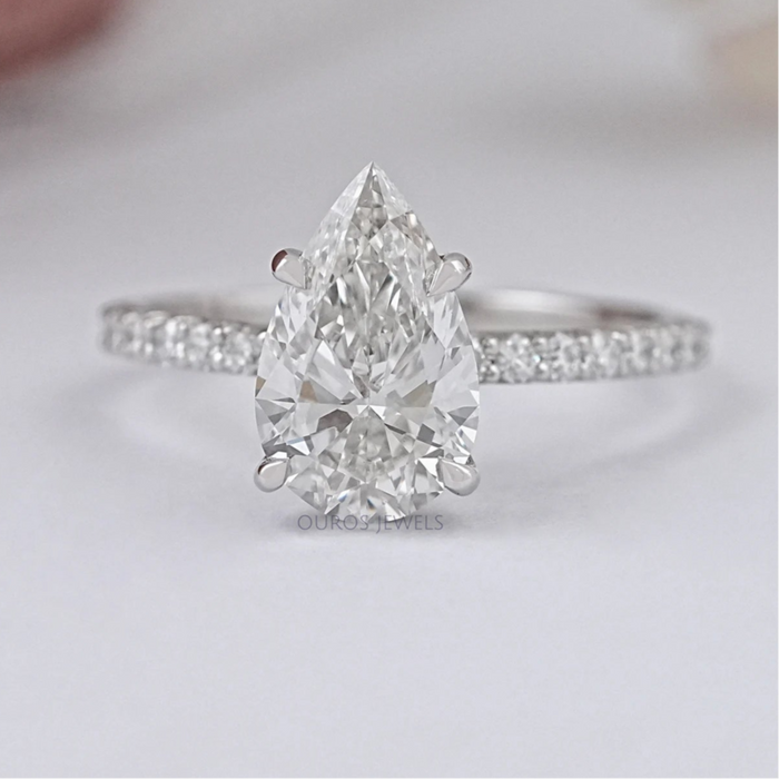 front view of pear-shaped lab diamond solitaire accent ring on grey fabric