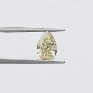 2.17 Carat Fancy Yellow Pear Cut Loose Diamond hold by tweezers against a plain background, emphasizing its clarity and vibrant yellow hue.