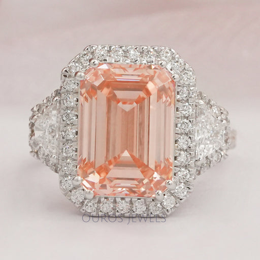 front view of pink emerald cut diamond three stone halo engagement ring