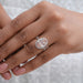 fancy pink oval cut lab diamond halo engagement ring on model's finger