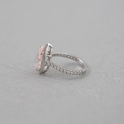 side view of pink pear cut diamond halo anniversary ring