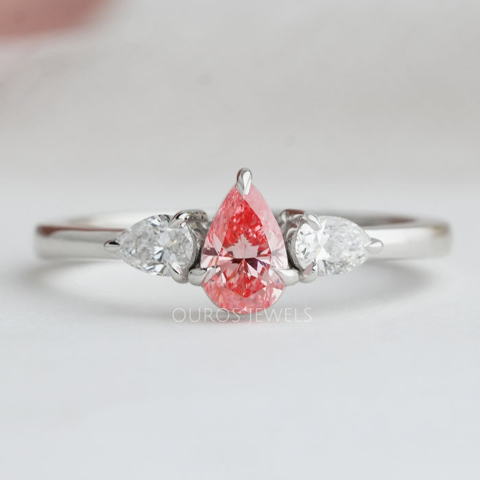 front view of pink pear cut lab diamond three stone engagement ring