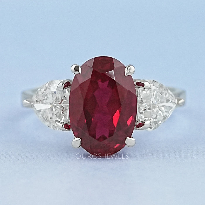 front view of oval ruby gemstone with heart diamond 3 stone engagement ring