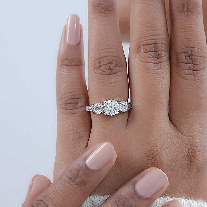 round cut diamond five stone engagement ring with white gold band in finger