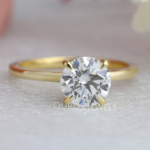 front view of round cut diamond hidden halo solitaire engagement ring yellow gold