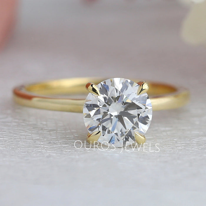 front view of round cut diamond hidden halo solitaire engagement ring yellow gold