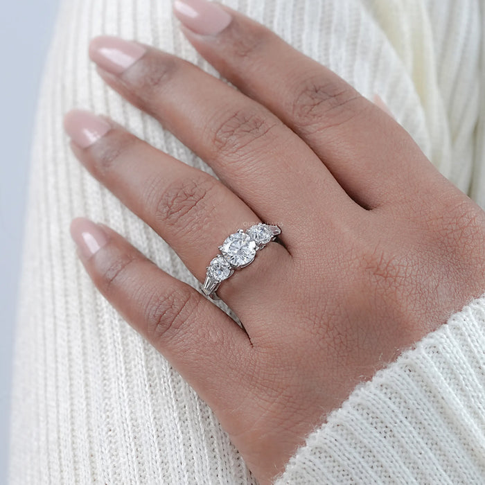 round cut diamond five stone engagement ring with white gold band on model's finger