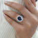 sapphire oval cut gemstone halo split shank engagement ring on model's finger