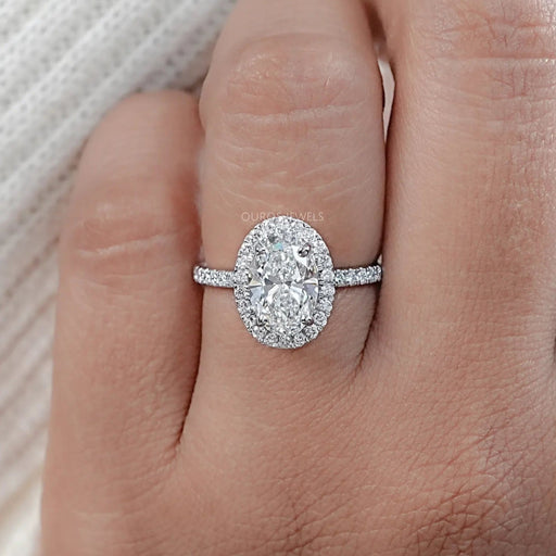 front angle view of oval cut lab diamond halo engagement ring in finger