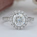 front view of round cut lab diamond halo engagement ring on grey fabric