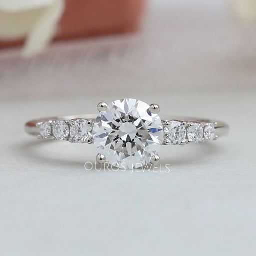 front view of 7 stone round-cut diamond solitaire accent engagement ring on fabric