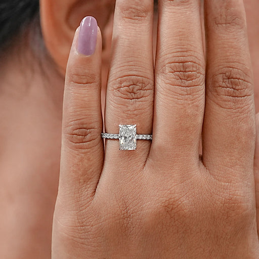 front view of radiant-cut lab diamond solitaire accent engagement ring in finger