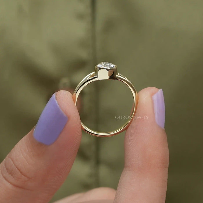 close view of step cut pear diamond bezel set engagement ring