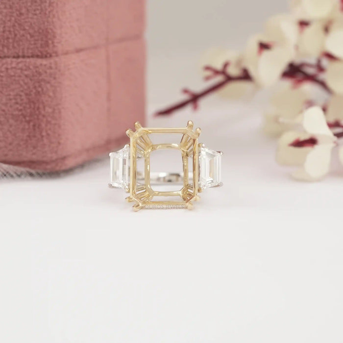 close view of step-cut trapezoid semi-mount three-stone wedding ring on fabric