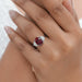 oval ruby gemstone and half moon diamond 3 stone engagement ring on model's finger