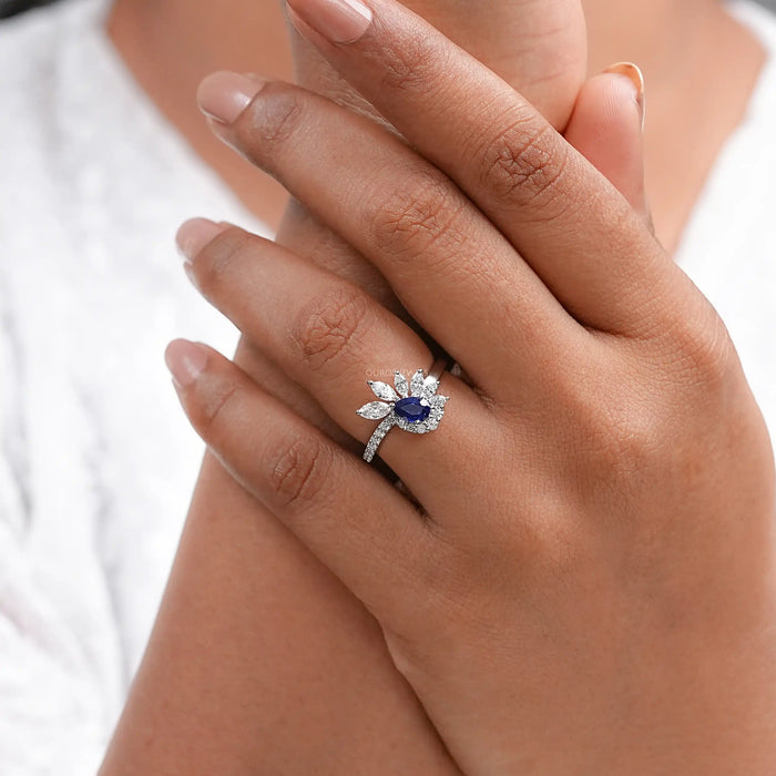 pear cut blue sapphire gemstone cluster bypass engagement ring on model's finger