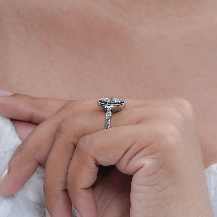 OEC round diamond surround with sapphire baguette halo wedding ring on model's finger