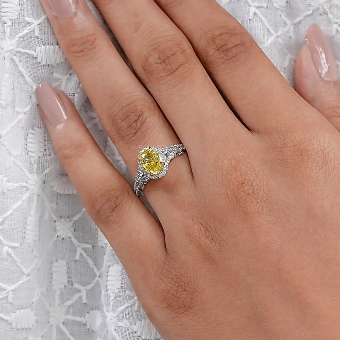 yellow oval cut diamond split shank halo engagement ring on model's finger