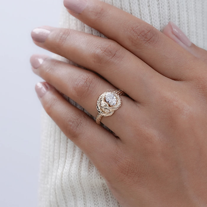 snake-shaped oval-cut diamond anniversary ring with yellow gold band on model's finger