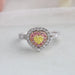 top view of yellow heart shaped diamond double halo engagement ring on grey fabric