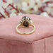 back view of black oval cut diamond three stone engagement ring on jewelry box