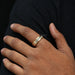 blue round cut lab grown diamond men's ring yellow gold on model's finger