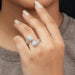 emerald & trilliant cut diamond halo bypass engagement ring on model's finger