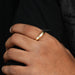 round cut hidden mens gold wedding ring with diamonds on finger