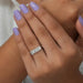 radiant cut diamond five stone wedding ring with white gold band on model's finger