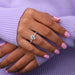 blue pear-cut lab-grown diamond halo colored engagement ring on model's finger