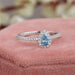 top view of blue pear-cut lab diamond halo colored engagement ring on jewelry box