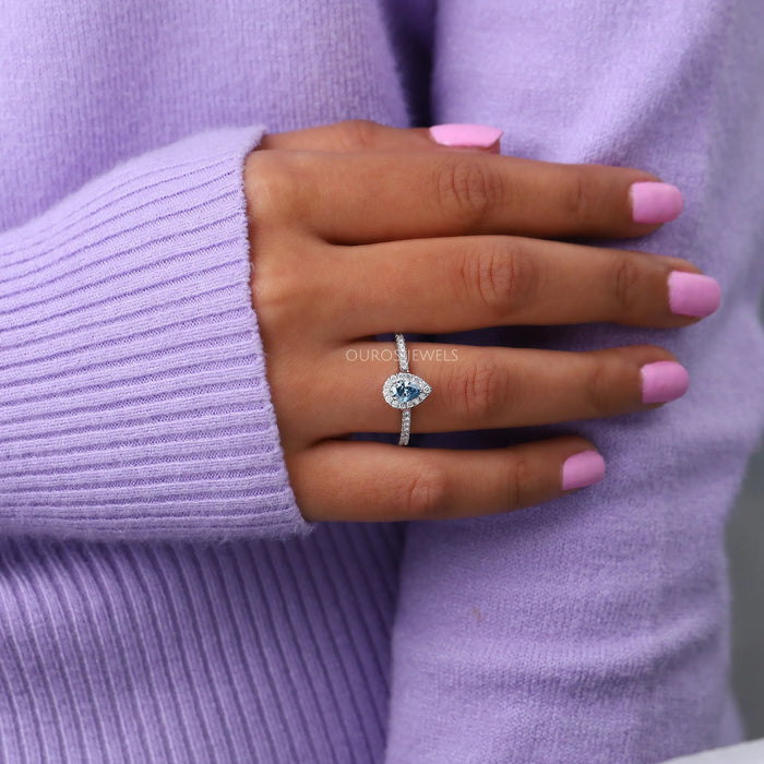 blue pear-cut lab-grown diamond halo colored engagement ring in finger
