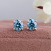 front view of blue round cut diamond solitaire stud earrings white gold