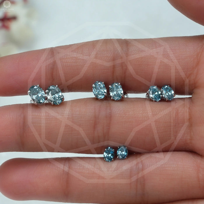 blue oval cut man made diamond studs earrings white gold shown on finger