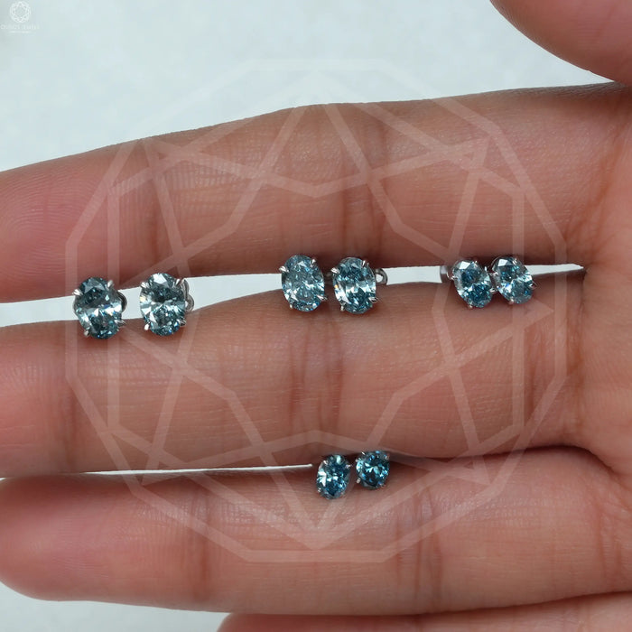 blue oval cut lab created diamond studs earrings white gold shown on finger