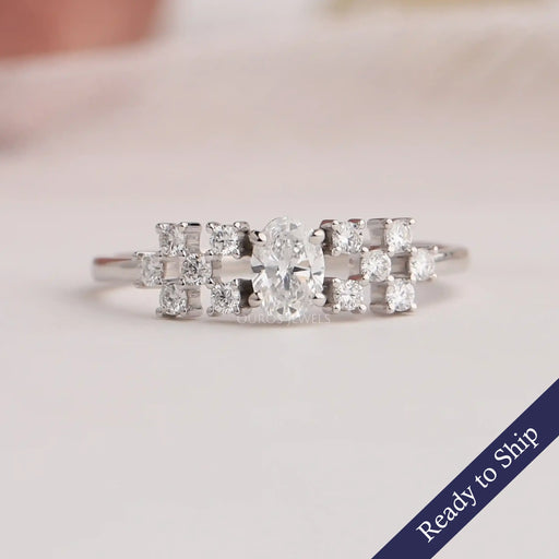 Front view of oval cut cluster diamond ring in 14k white gold, crafted with side small round diamonds.