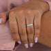 emerald-cut diamond five-stone wedding ring with white gold band on model's finger