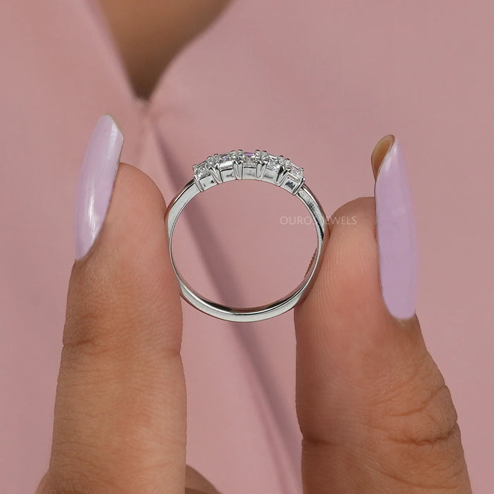 close view of emerald-cut lab diamond five-stone wedding ring with white gold band