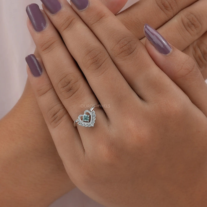 In finger front view of cushion cut diamond engagement ring crafted with halo setting & heart shape style.