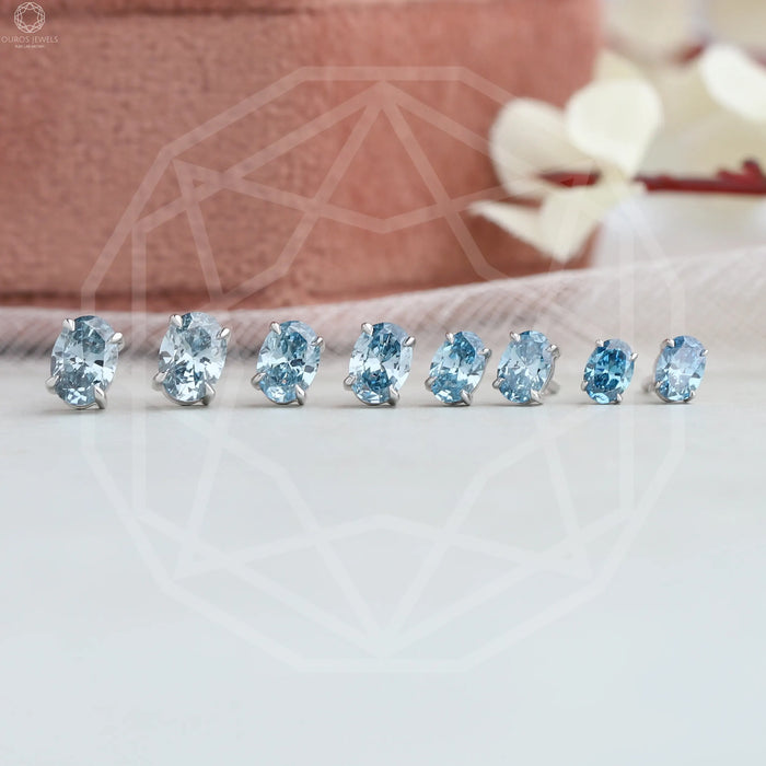 front view of blue oval cut lab made diamond studs earrings white gold