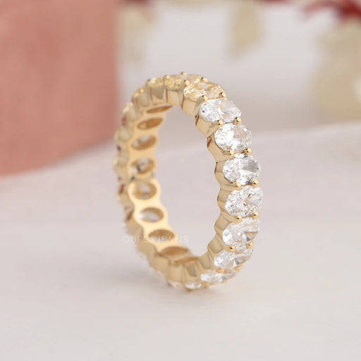 Side look of prongs and oval brilliant cut lab diamonds in eternity band