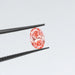 0.6 carat pink lab grown oval diamond loose held with tweezer