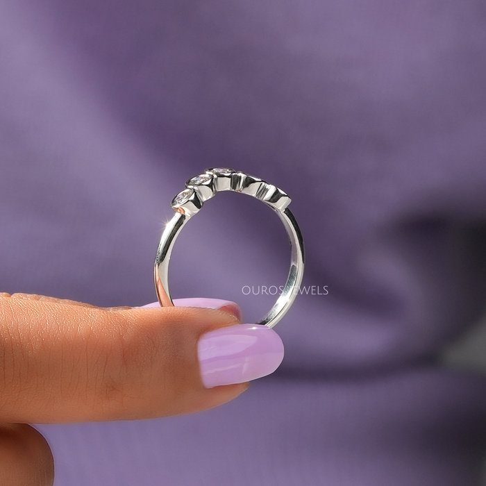 close view of 5 stone round cut lab diamond bezel set curved wedding band