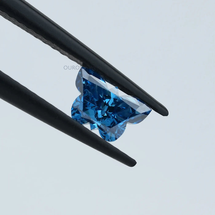 0.55 carat blue butterfly cut lab grown loose diamond holded with tweezer