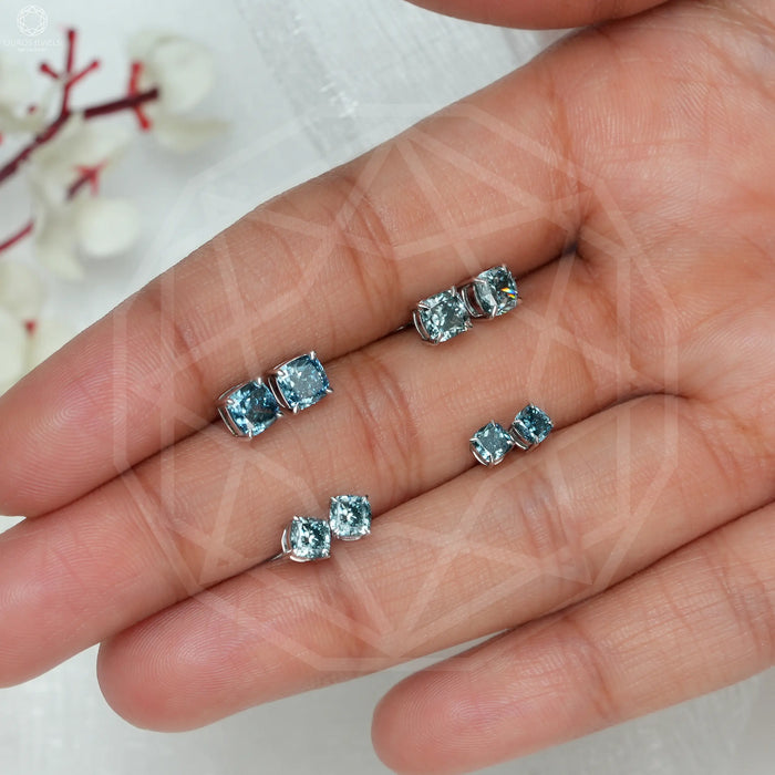 blue cushion cut man made diamond stud earrings white gold on finger view