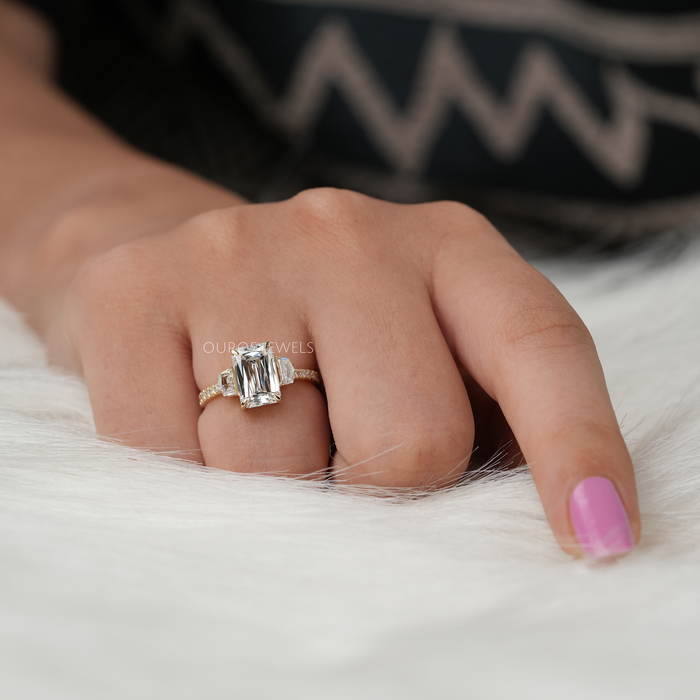 criss cut diamond three stone engagement ring with yellow gold band on model's finger