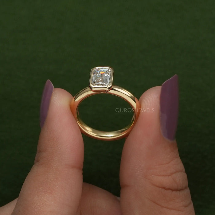 close view of emerald cut diamond bezel set solitaire engagement ring