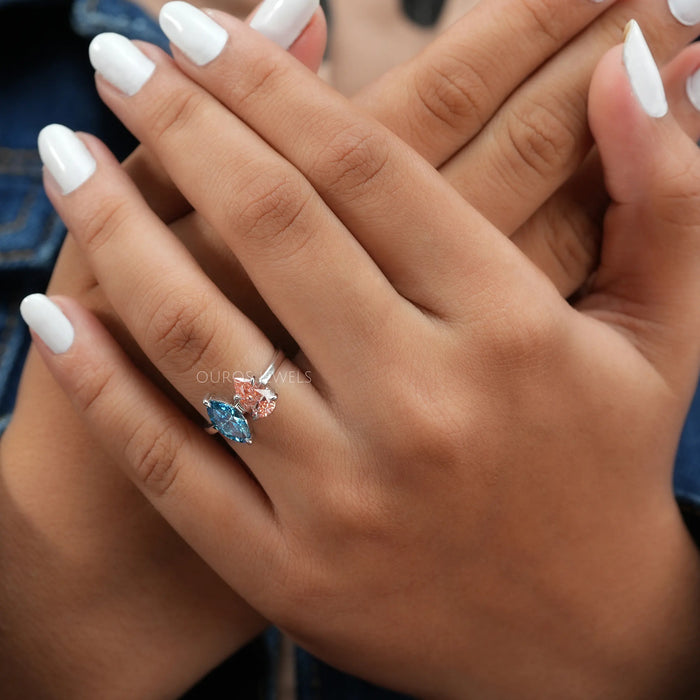blue marquise and pink pear diamond toi et moi engagement ring on model's finger