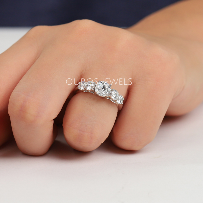 round-cut diamond bezel-set curved wedding band with white gold band on model's finger