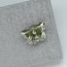 side view of green butterfly shaped lab diamond on matte material